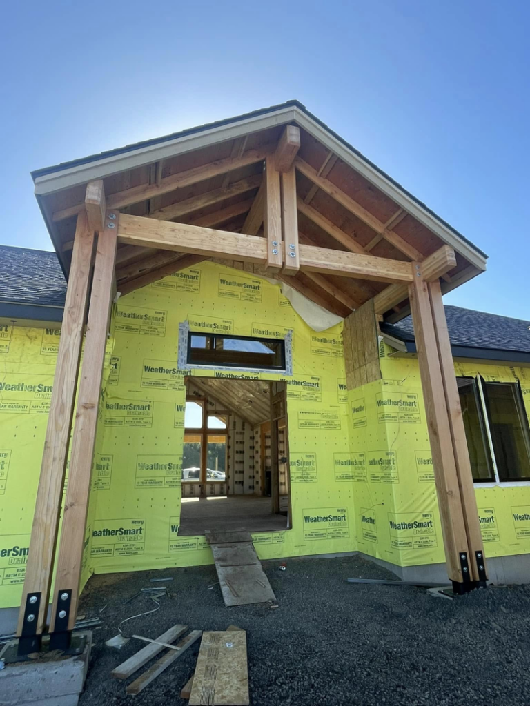 Front entrance of a house under construction with exposed wood framing and sheathing by Palma's Painting & Misc. in Corvallis, OR.