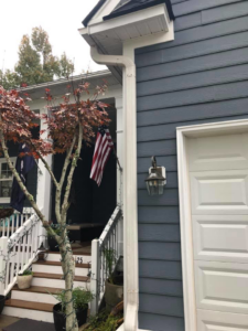 The front of a house showcasing new siding, gutters, and a garage door installed by American Shearing LLC in North Charleston, SC.
