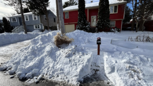 A house with heavy snow in the driveway, ready for snow removal by Build Brothers in Providence, RI