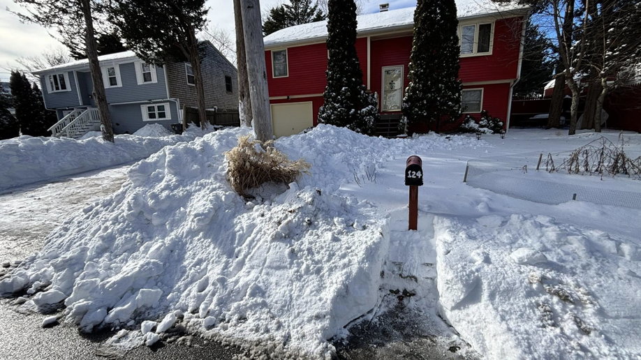 A house with heavy snow in the driveway, ready for snow removal by Build Brothers in Providence, RI