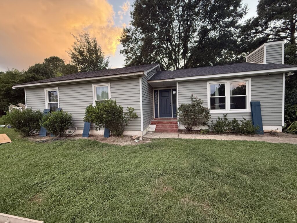 The exterior of a house with newly installed siding and windows, a handyman service by Elite Xteriors NC in Cary, NC.