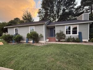 The exterior of a house with newly installed siding and windows, a handyman service by Elite Xteriors NC in Cary, NC.