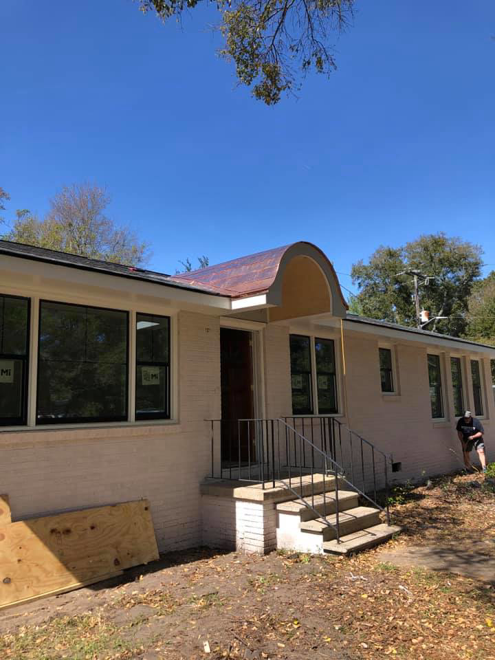 A house undergoing renovation with new windows and a copper awning installation by American Shearing LLC in North Charleston, SC.