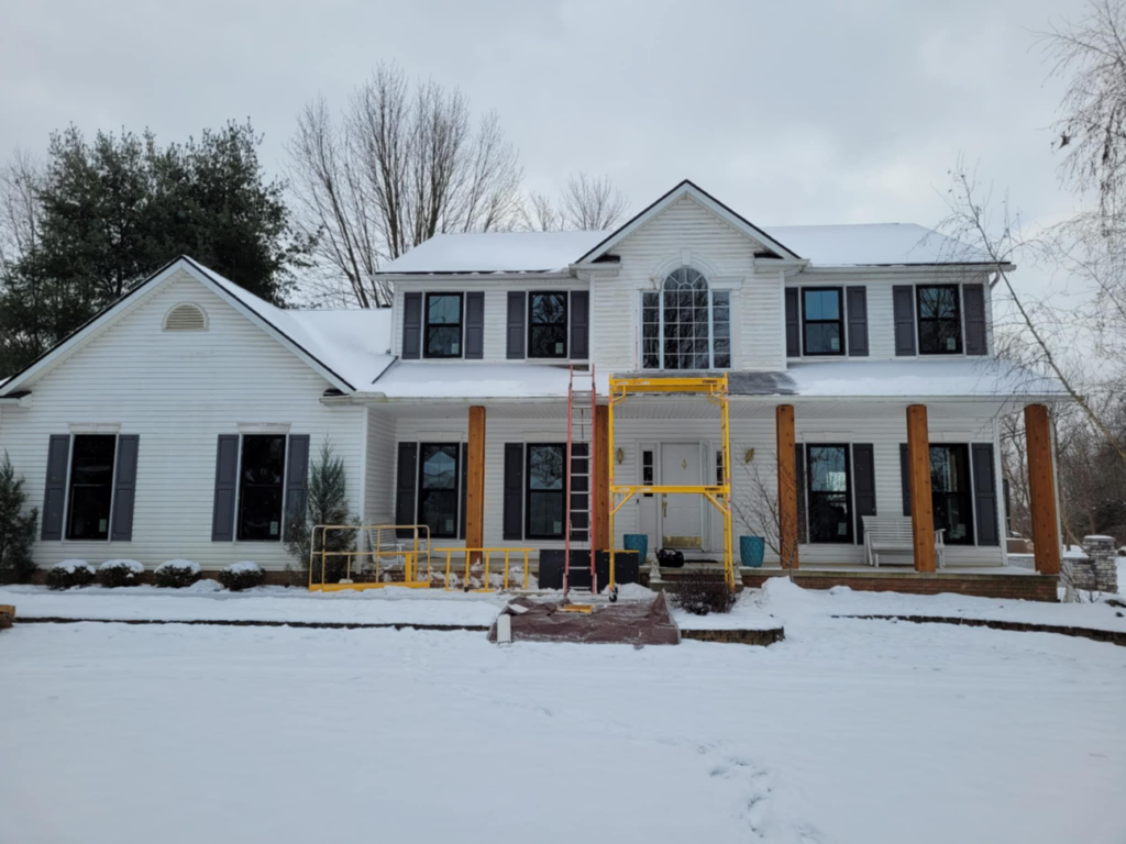 House exterior with scaffolding and ladders set up for a renovation project by 1st Choice Windows in Canton, OH.