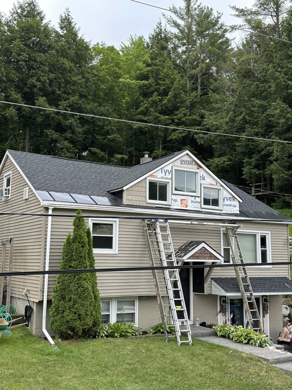 House undergoing roofing and siding installation with Tyvek wrap by Next Generation Carpentry LLC in Bennington, VT.