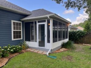 An exterior view of a house featuring a newly built screen room addition by NRG Industries in Tallahassee, FL.