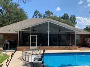 A house with a large screened-in patio overlooking a swimming pool, a project by NRG Industries in Tallahassee, FL.