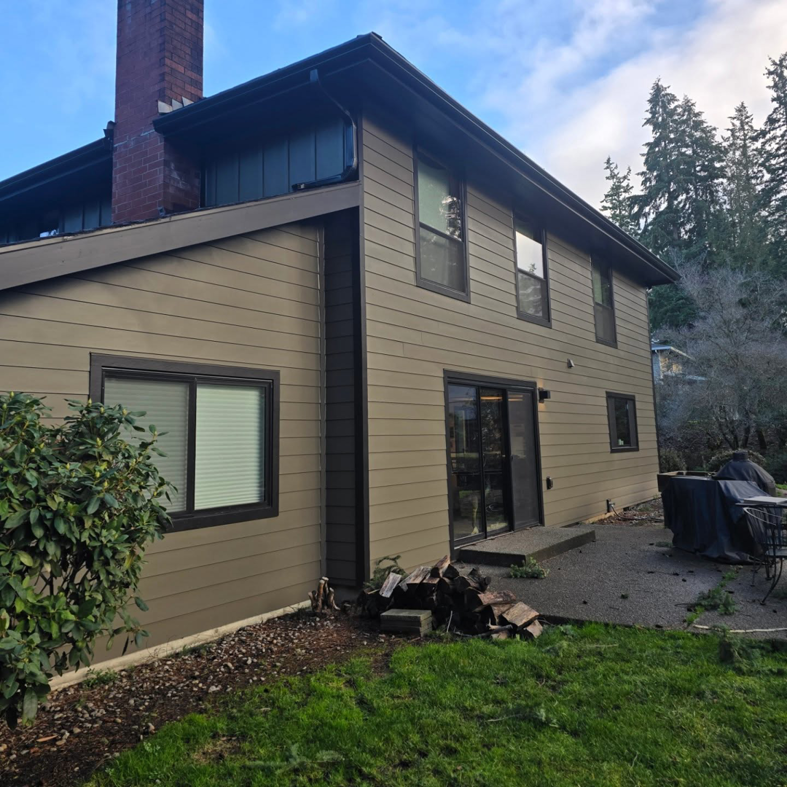 The side exterior of a house with new siding, gutters, and a brick chimney by Final Touch Construction, LLC in Tukwila, WA.