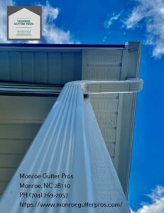 Side view of a house featuring both a traditional downspout and a stylish rain chain, installed by Monroe Gutter Pros in Charlotte, NC.