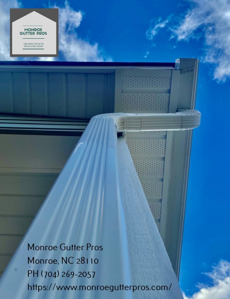 Side view of a house featuring both a traditional downspout and a stylish rain chain, installed by Monroe Gutter Pros in Charlotte, NC.