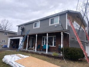 A house undergoing siding replacement and window installation by Carl Gardner Contracting in Syracuse, NY.