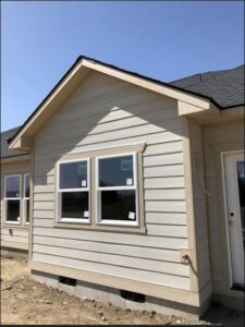 Exterior view of a house with newly installed siding and windows, completed by Fisher Construction, LLC in Selah, WA.