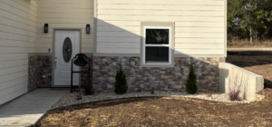 House exterior with new stone veneer siding, a concrete path, and landscaping by MHK Yard & Gravel in Manhattan, KS
