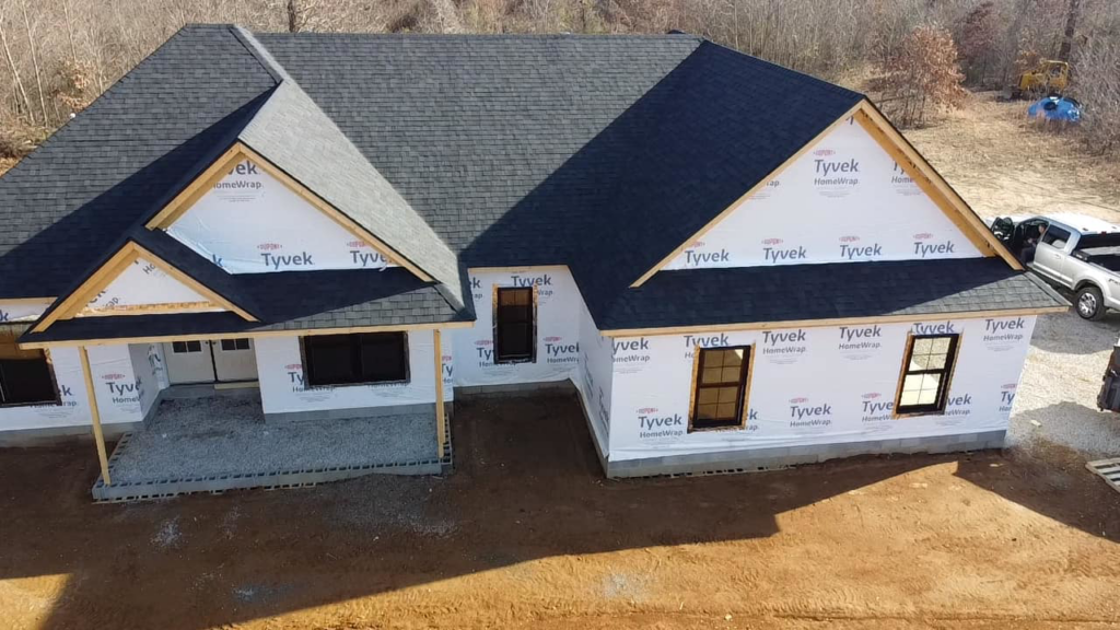 A house under construction with a newly installed shingle roof and Tyvek wrap by SJL Contracting, LLC in Owensboro, KY.