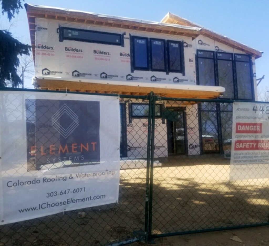 A house under construction with a roofing and waterproofing banner by Element Systems in Wheat Ridge, CO