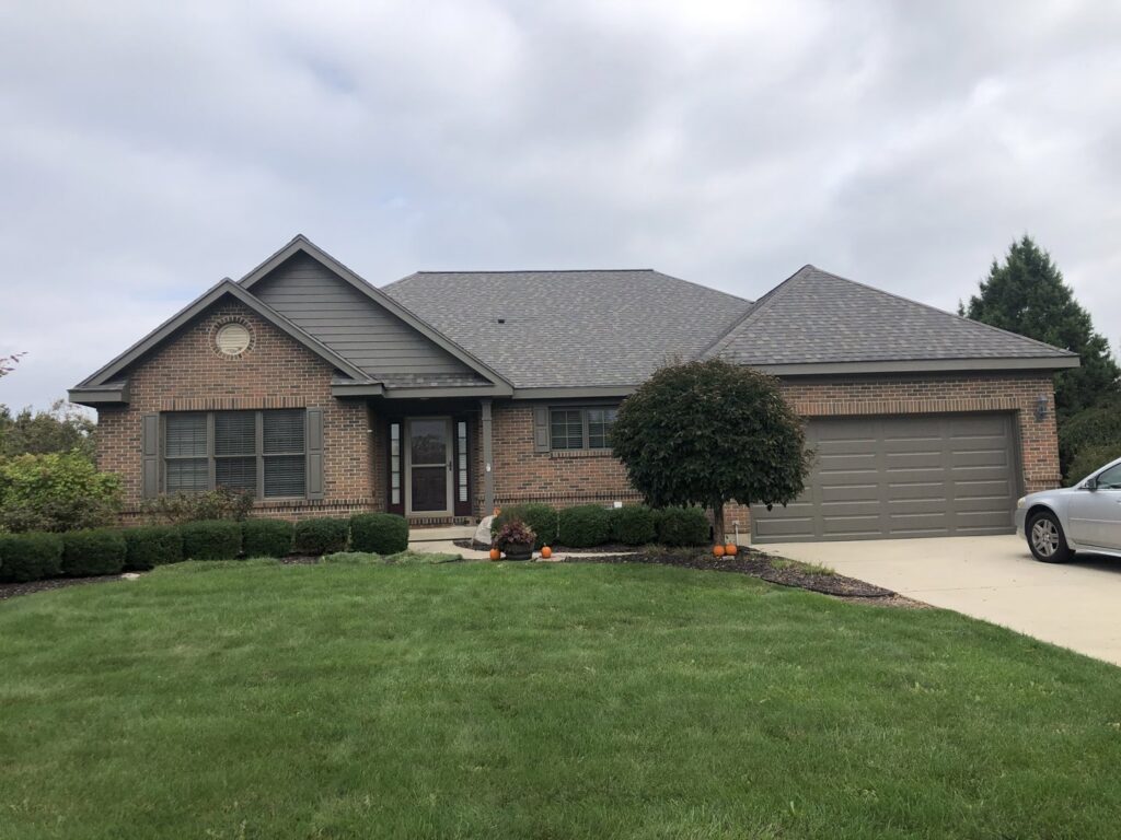 A residential house with a new shingle roof and updated siding, completed by Mp painting and roofing LLC in Dayton, OH