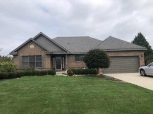 A residential house with a new shingle roof and updated siding, completed by Mp painting and roofing LLC in Dayton, OH