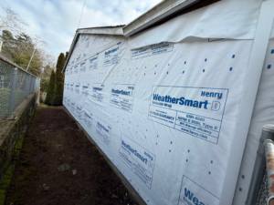 WeatherSmart D house wrap being installed on the side of a house by CJ Hansen Construction in North Bend, OR.