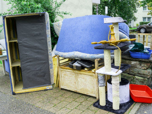 A pile of household junk including a cat tree, mattress, and other furniture left outdoors for removal by Trashouts Junk Removal in Pembroke Pines, FL.