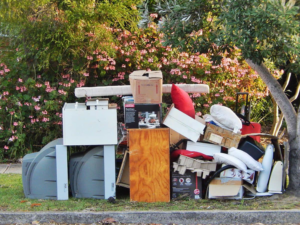 Household junk, including boxes and an old TV, placed curbside for pickup by Avery's Junk Removal & Hauling in Trenton, MI.
