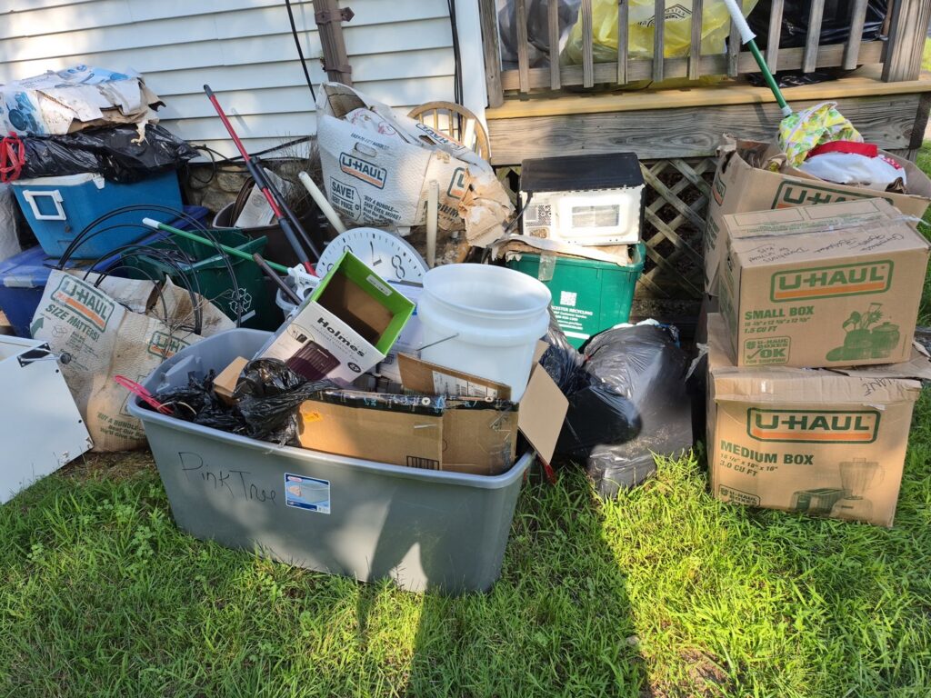 A large pile of household junk and boxes outside a home for removal by Junk Dunkers in Wrentham, MA