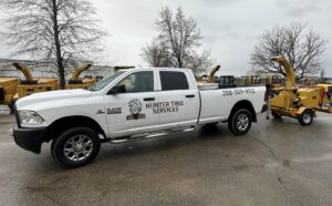 A Hunter Tree Services pickup truck towing a wood chipper, ready for tree service jobs in Nampa, ID.