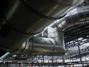 Large metal HVAC ductwork being installed in a building under construction, showcasing a project by McKamish, Inc. in Pittsburgh, PA