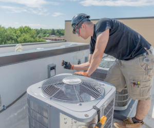 A skilled HVAC technician performing maintenance on a rooftop air conditioning unit for Precision Air Conditioning & Heating, LLC in Memphis, TN.