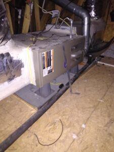 An HVAC unit installed in an attic, showing ductwork and wiring by Holy City Remodel in North Charleston, SC.