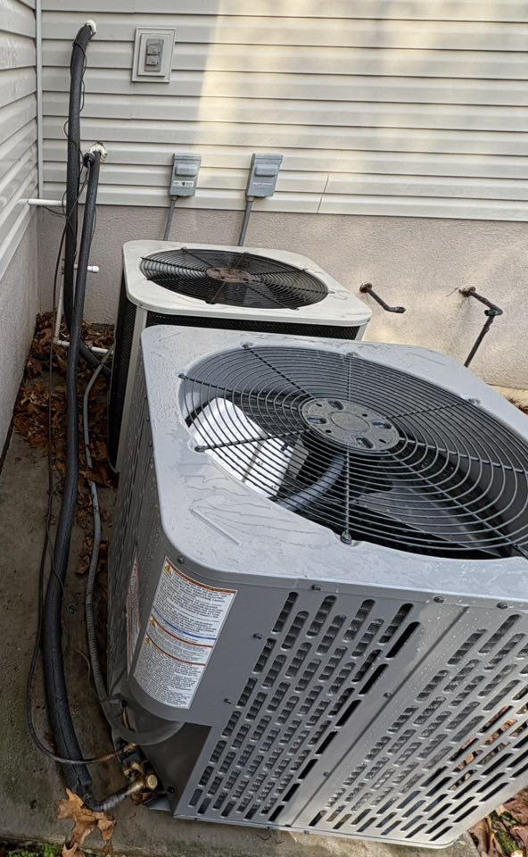 Two outdoor HVAC units installed next to a home by HomeFront Services LLC in Fayetteville, AR