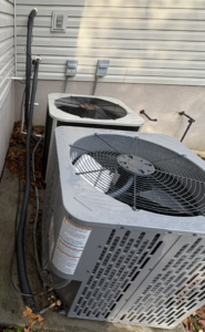 Two outdoor HVAC units installed next to a home by HomeFront Services LLC in Fayetteville, AR