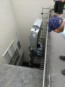 Technicians using a lift to move an HVAC unit during installation or removal for Our Place Air & Home Repair in Orlando, FL.