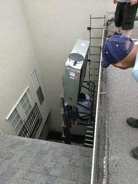 Technicians using a lift to move an HVAC unit during installation or removal for Our Place Air & Home Repair in Orlando, FL.