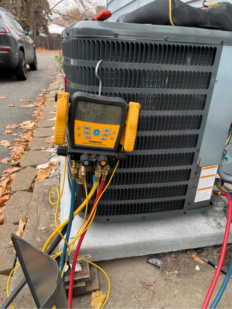 Outdoor HVAC unit undergoing repair or maintenance with gauges attached by Epic Electric, Heating, Cooling & Plumbing in Spokane, WA