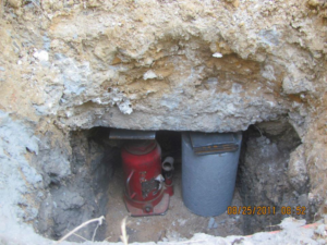 A hydraulic jack used for foundation repair next to a concrete pier by Metro-Tex Foundation in Plano, TX