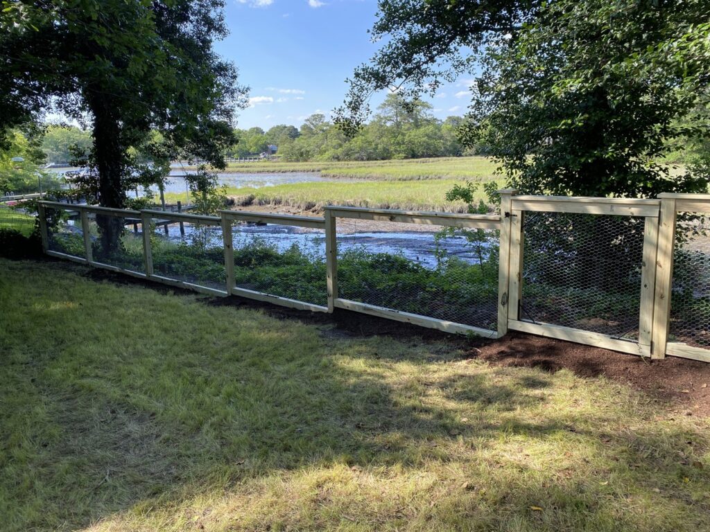 An illuminated composite deck with multi-level steps and railings at night, installed by Dutch Deck and Fence in Norfolk, VA.