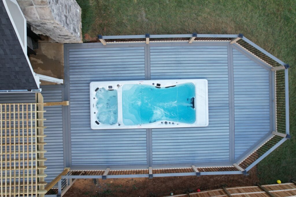 An illuminated pool area with a slide and patio lights at dusk, showcasing a completed project by Southern Pool Solutions in Knoxville, TN.