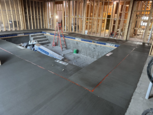 An indoor pool under construction with concrete shell and surrounding wooden framing by Sunrise Pool Builders, Inc. in Rockford, IL