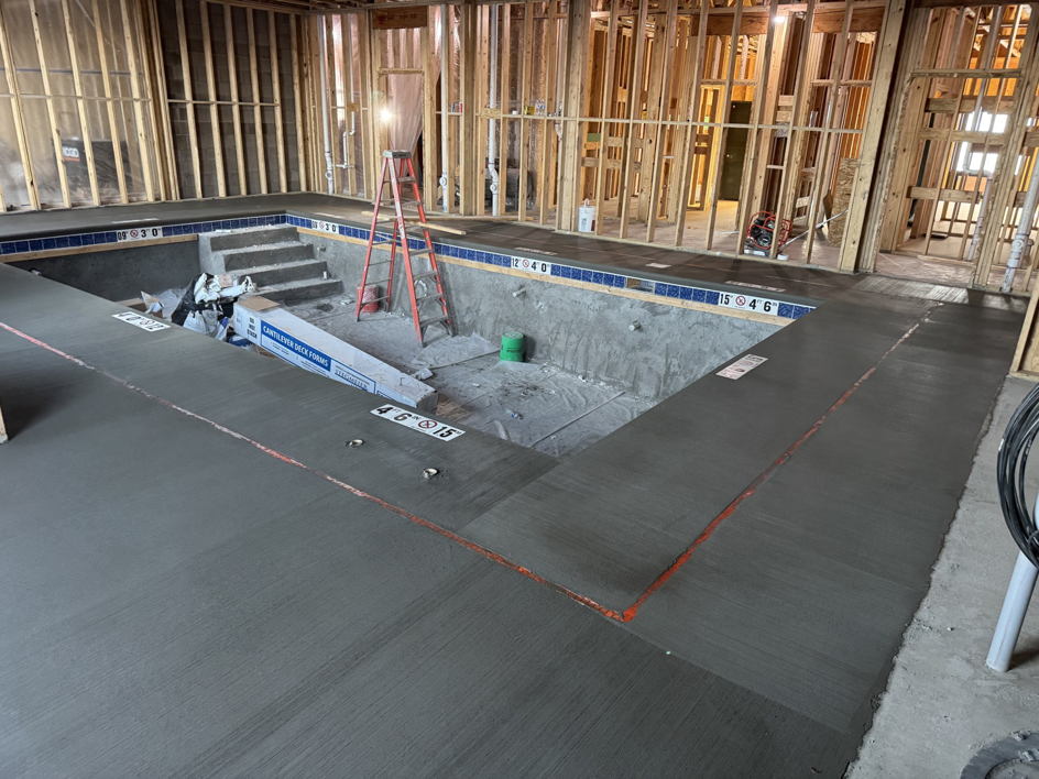 An indoor pool under construction with concrete shell and surrounding wooden framing by Sunrise Pool Builders, Inc. in Rockford, IL