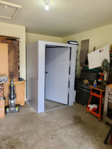 An indoor safe room storm shelter expertly installed in a residential garage by Taylor Storm Shelters in Stillwater, OK.