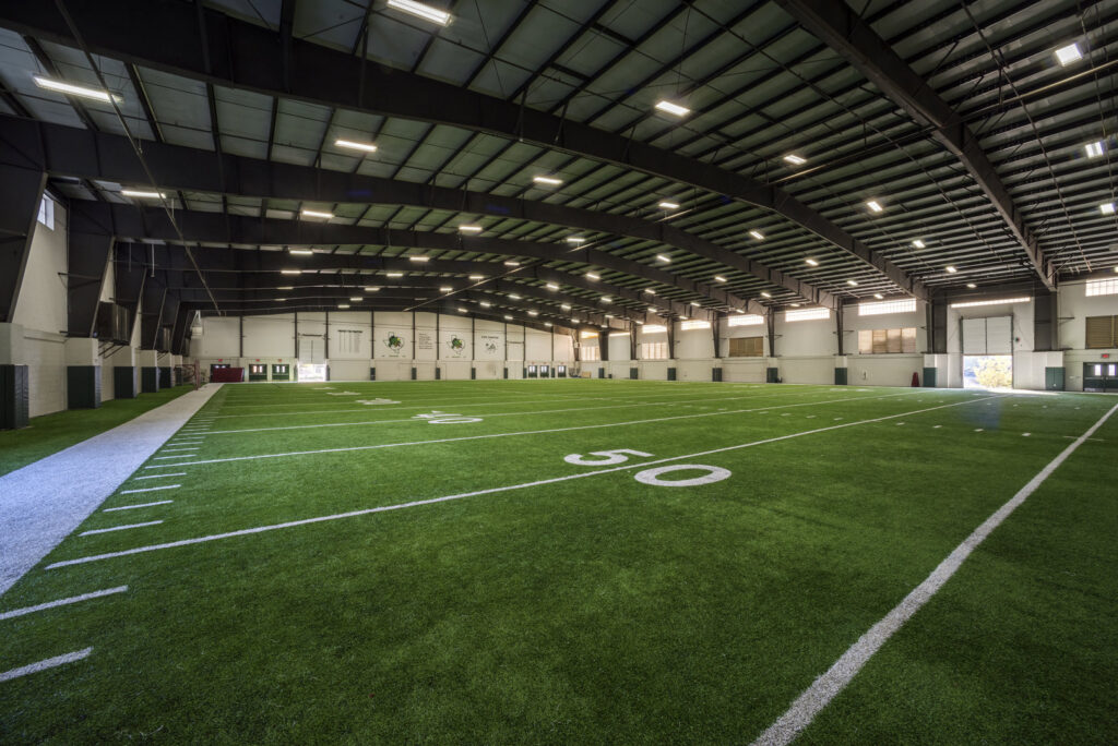 Interior of a large indoor sports facility with an artificial turf field, built by Reeder General Contractors, Inc. in Fort Worth, TX