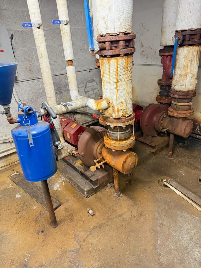 Industrial HVAC pumps and pipes showing rust, serviced by Comfort Mechanical Heating and Cooling in Ann Arbor, MI.