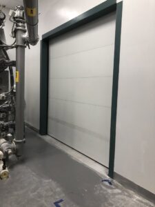 A modern industrial overhead door installed in a commercial facility by Overhead Door Company of Columbus in Columbus, GA.