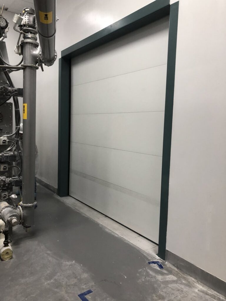 A modern industrial overhead door installed in a commercial facility by Overhead Door Company of Columbus in Columbus, GA.
