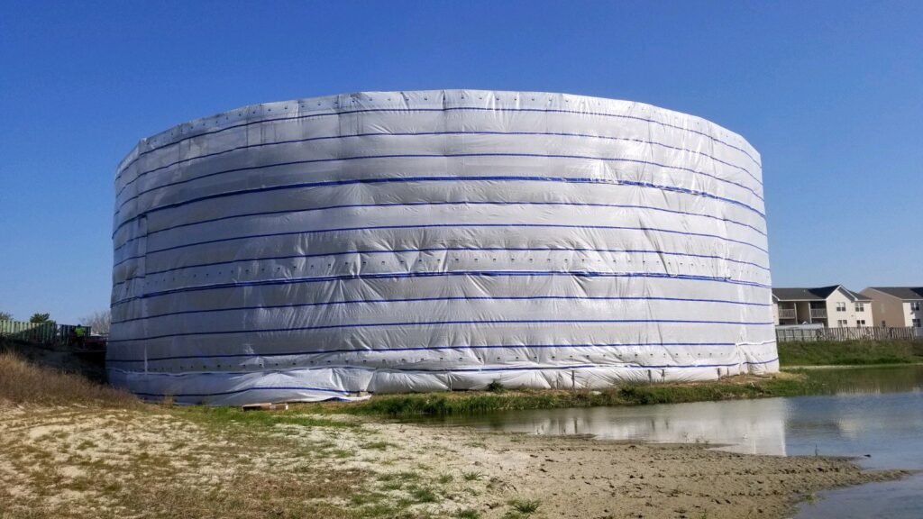 A large industrial tank wrapped in protective sheeting for surface preparation by WW Enroughty & Son, Inc. in Richmond, VA.