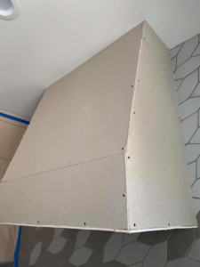 Initial drywall framing for a custom range hood project by Plasters of Italy in Plano, TX