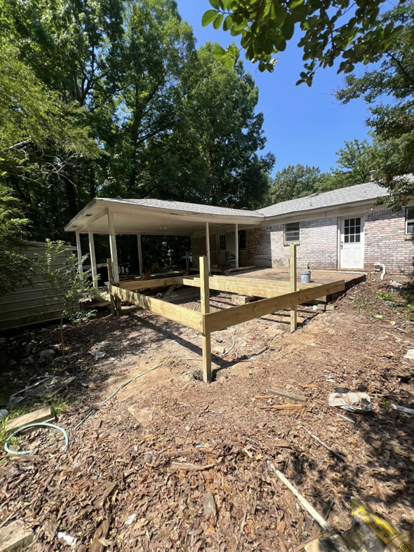 Initial framing and support posts for a new wooden deck in a backyard by JD Handyman service LLC in Miami, FL.