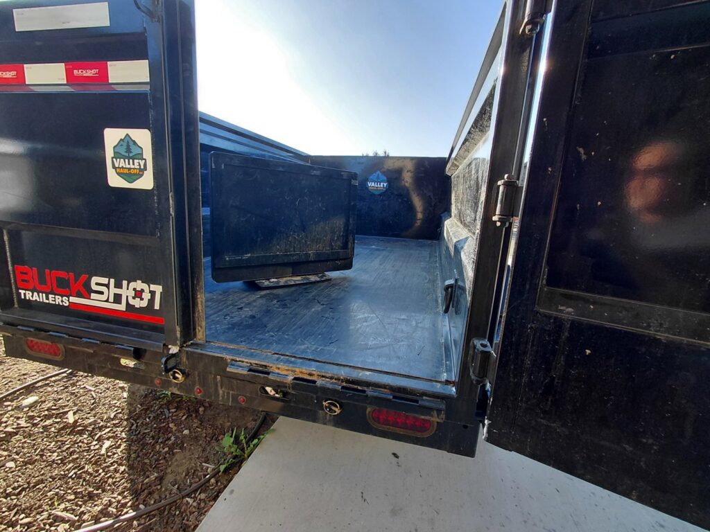The inside of a Valley Haul Off LLC dump trailer containing a television and other items collected for junk removal in Visalia, CA.