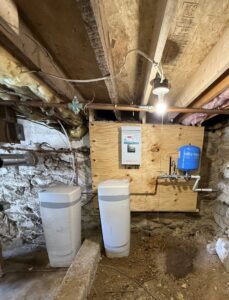 An installed water treatment system and blue pressure tank by S & L Water Solutions in Hagerstown, MD.