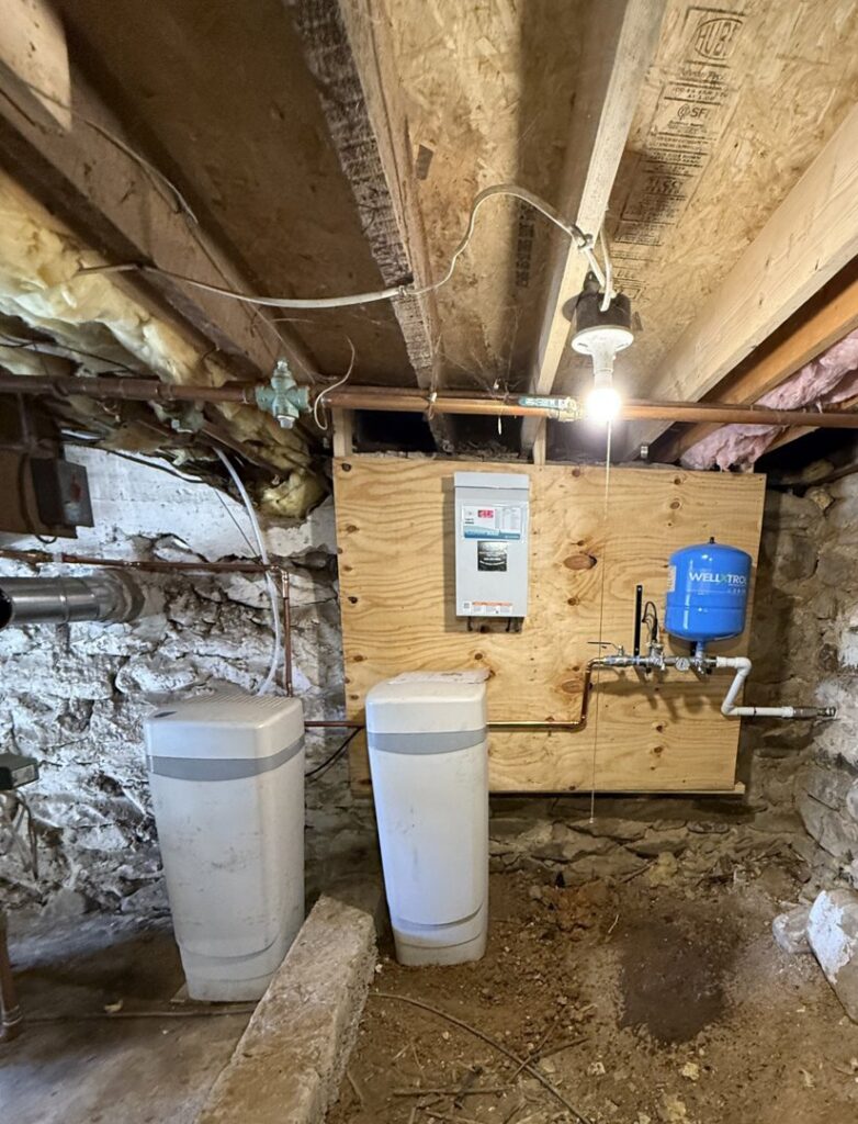 An installed water treatment system and blue pressure tank by S & L Water Solutions in Hagerstown, MD.